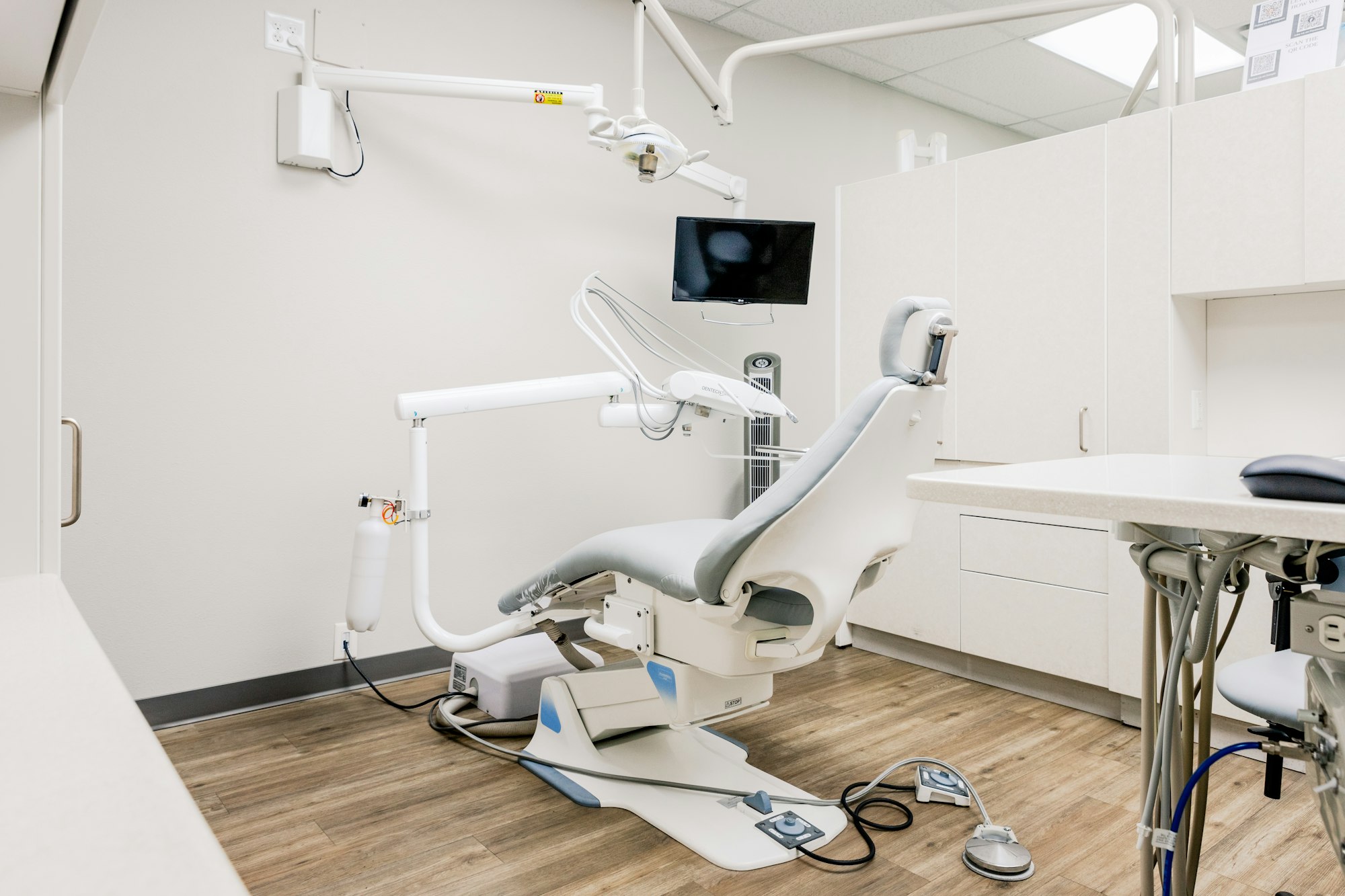 Bright, modern dental treatment room with a patient chair and overhead light